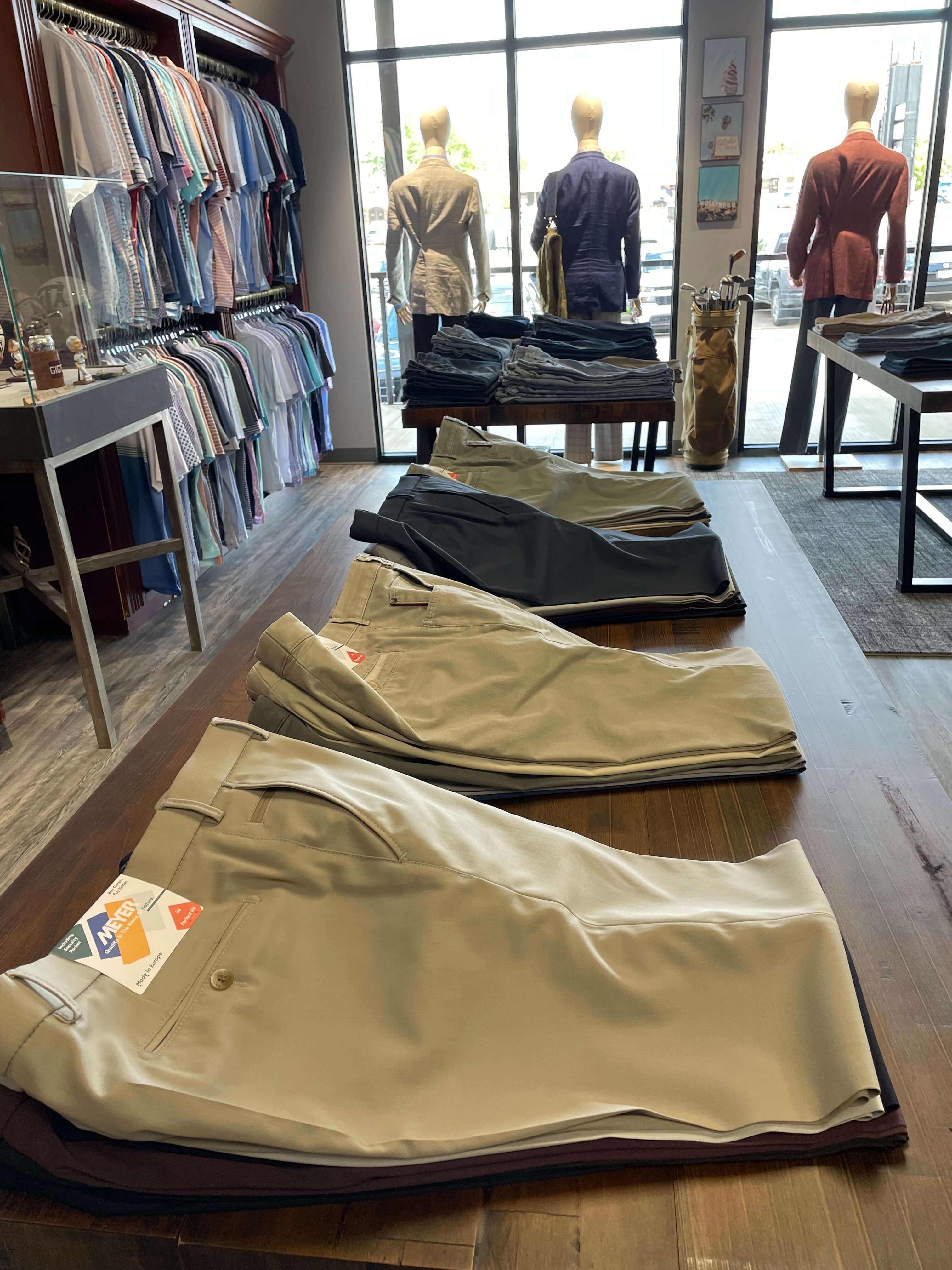Casual pants stacks on display table in JwR's store.